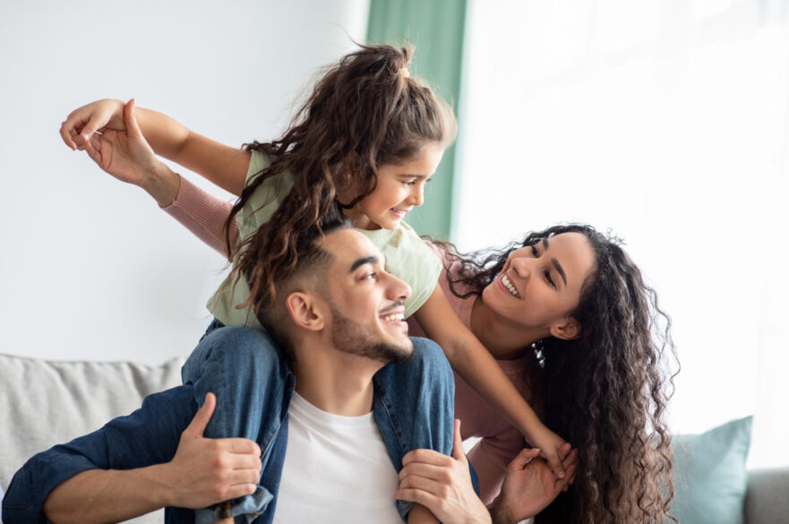 Parents smiling with their young daughter