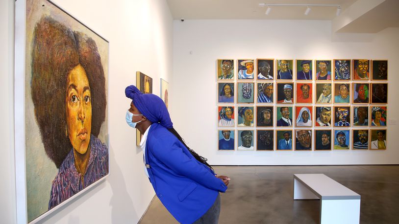 woman looking closely at a painting at contemporary art gallery in dayton