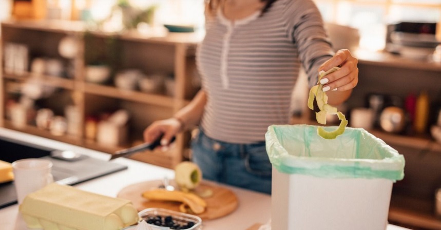 Woman using indoor composting bin.