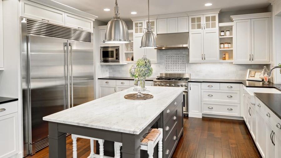 White quartz countertops in a large home kitchen.