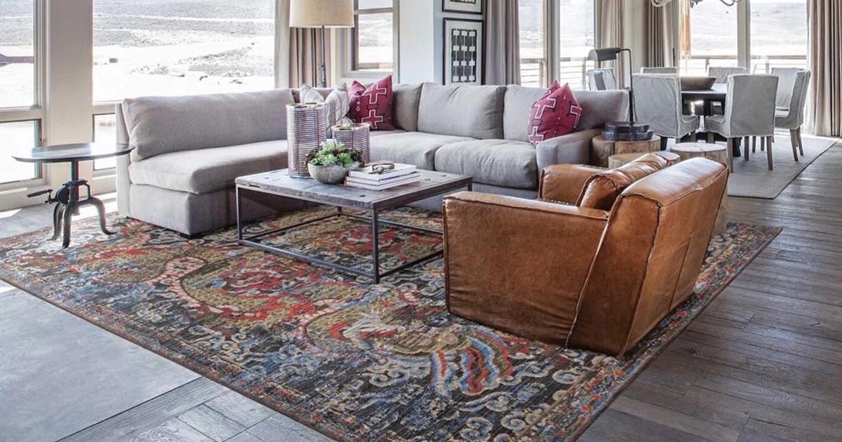 Area rug adds color to living room with hardwood floors.