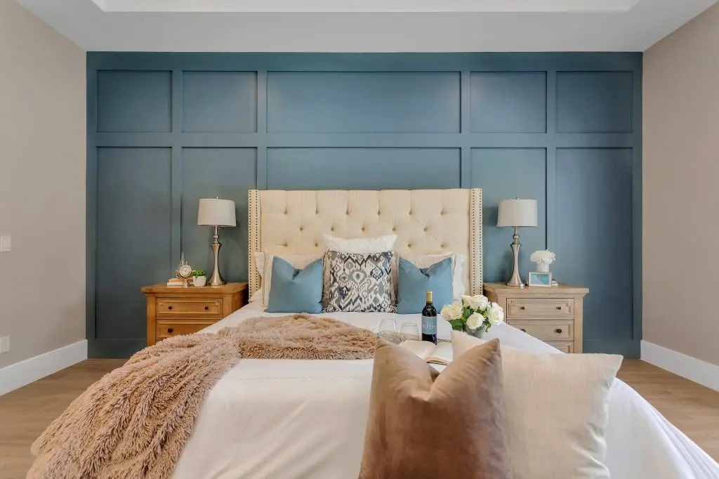 Blue accent wall brings bold color into a bedroom.