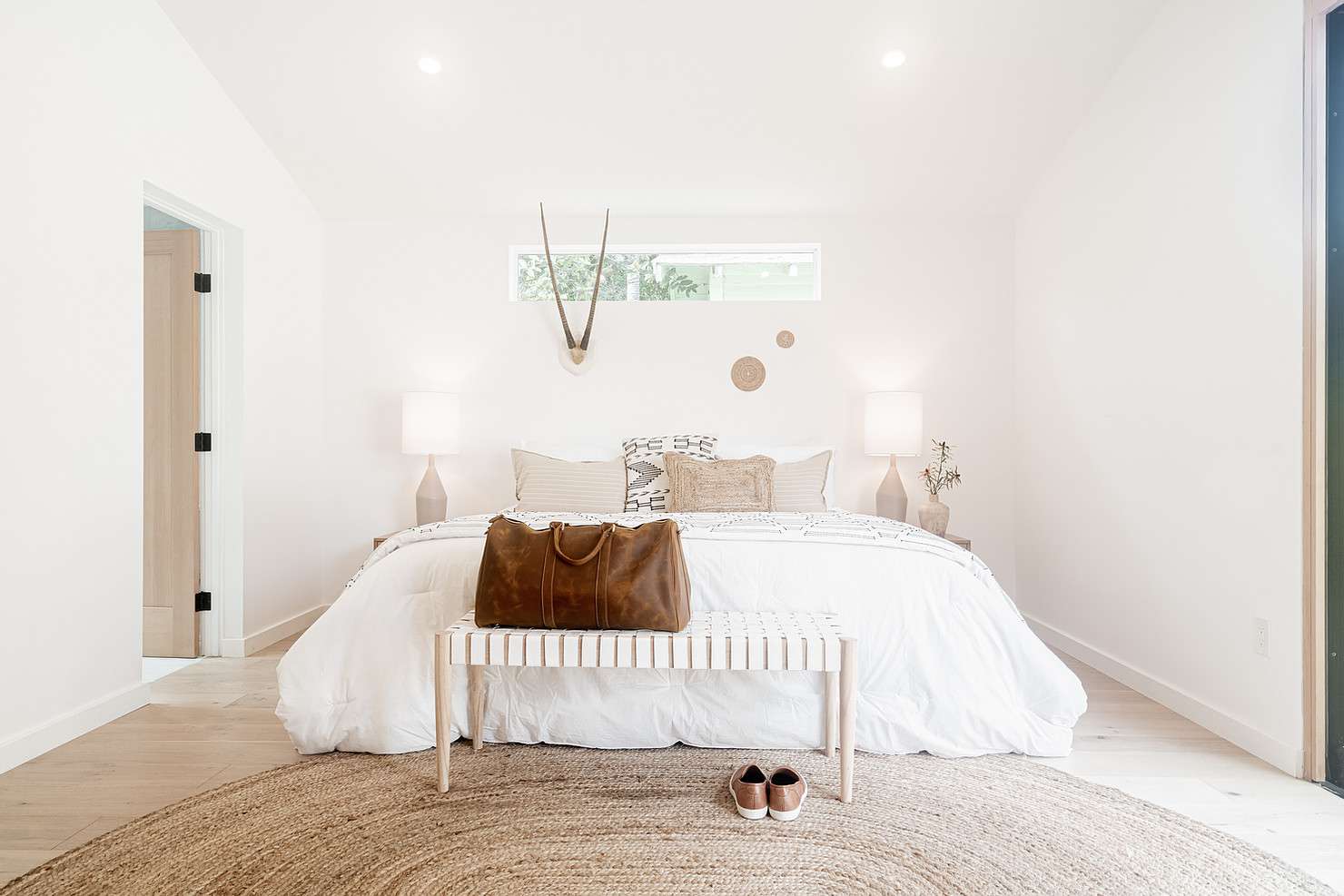 Crisp, clean bedroom with white walls and bedding
