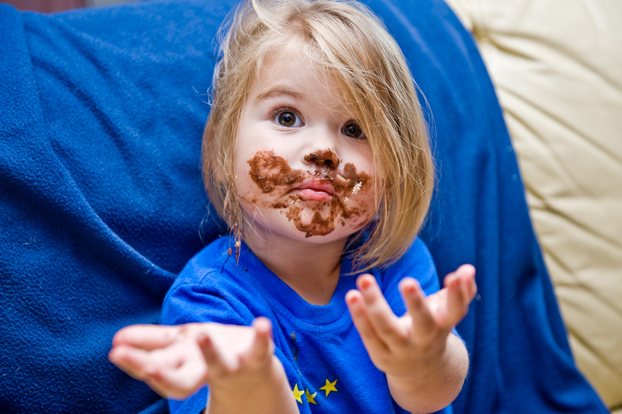 Child with chocolate on the furniture.