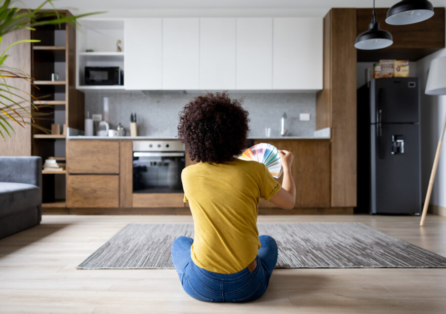 Woman sitting in her living room visualizing paint colors for her walls.