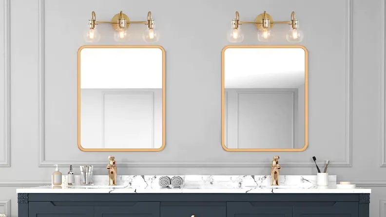 Double bathroom vanity and mirrors with exposed bulb lighting above it.