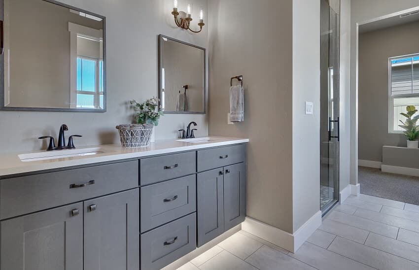 Gray painted vanity cabinets provide a pop of color in neutral bathroom.