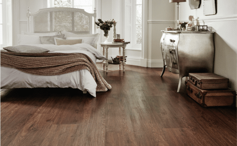Luxury vinyl flooring material mimics the look of real wood in a luxuriously designed bedroom.