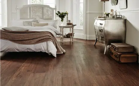 Luxury vinyl flooring material mimics the look of real wood in a luxuriously designed bedroom.