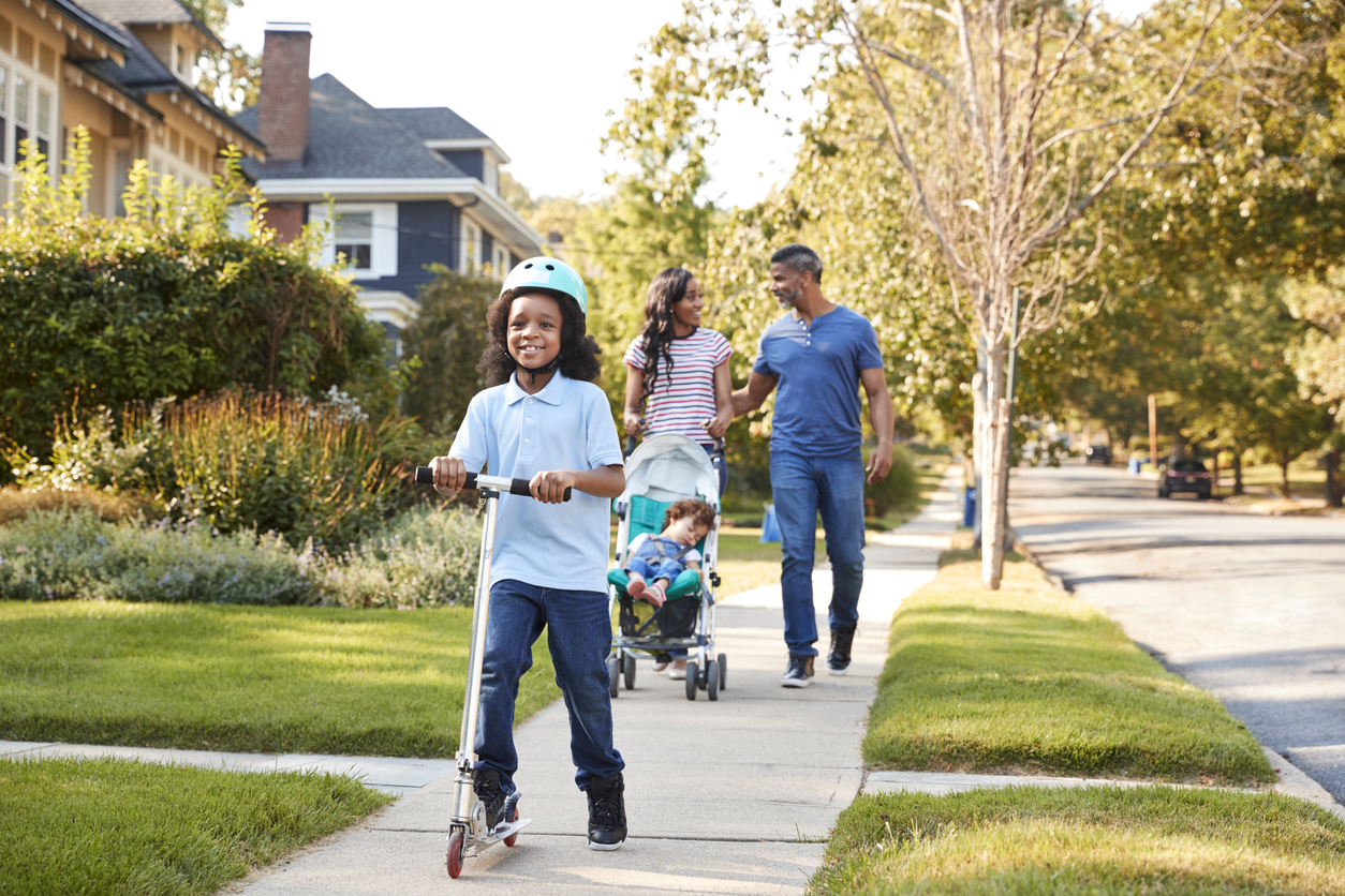 Family enjoys a walk down their suburban neighborhood street.