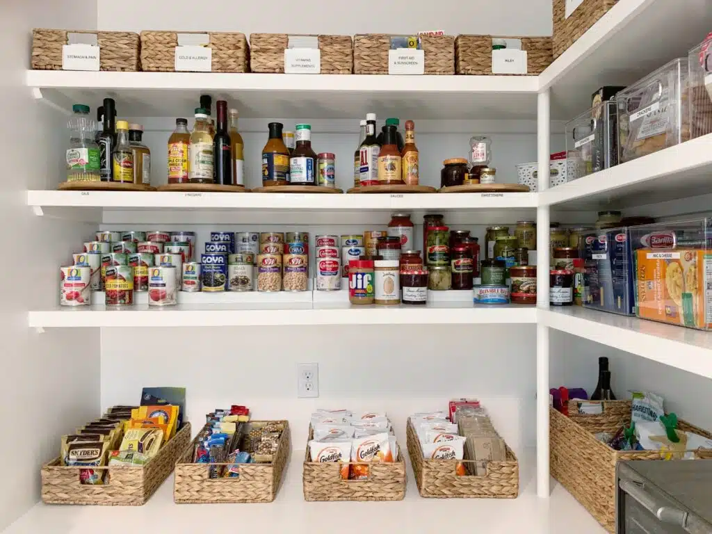 A very well-organized walk-in pantry, with baskets and labels contributing to organization 