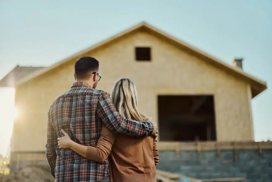 couple standing in front of their new construction home