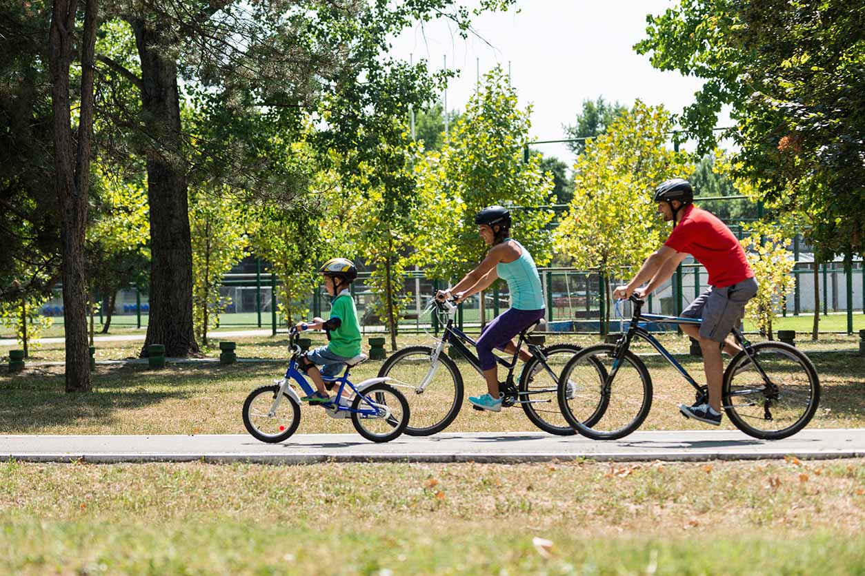 family riding bikes in a park