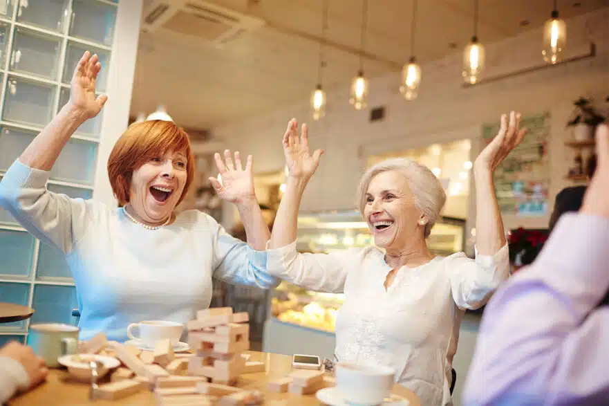 women excited while playing a game of Jenga